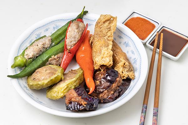 Variety of yong tau fu or stuffed tofu, popular Chinese food in Plate of Yong Tau Foo with sauces